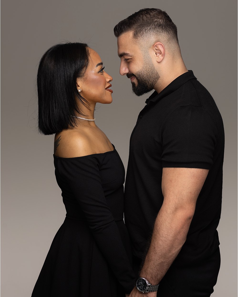 Couple portrait in black on a grey backdrop