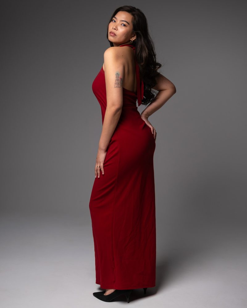 Woman in a long red dress on a grey backdrop