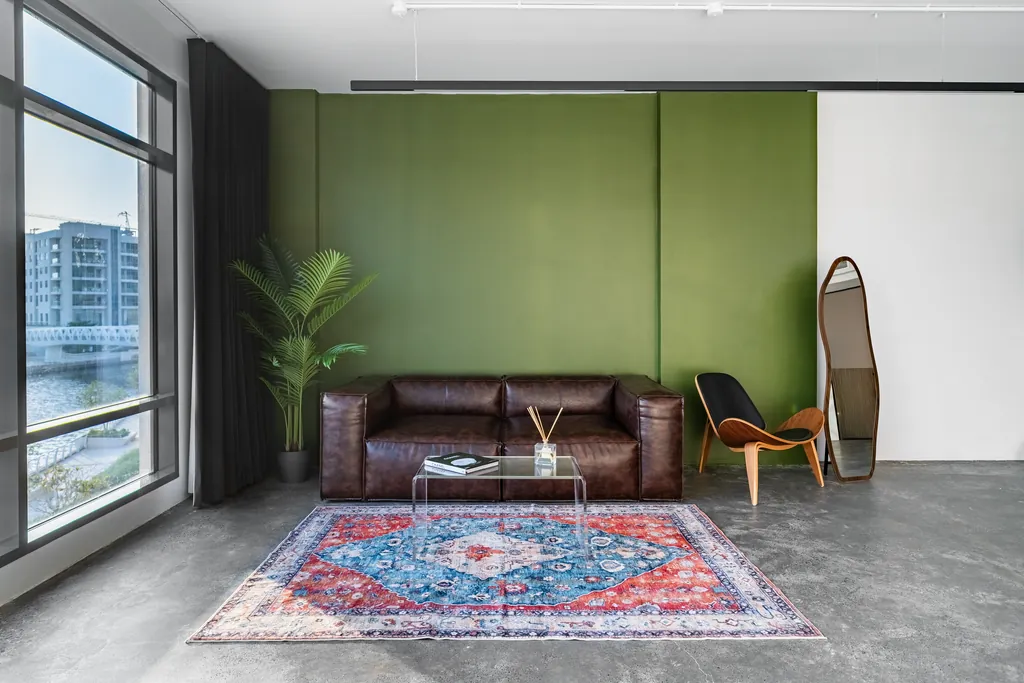 The styled set: leather sofa, rug and green wall